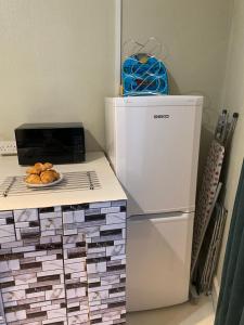 a kitchen with a refrigerator and a plate of bread at Whitchurch Shropshire Town duplex flat in Whitchurch