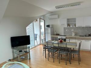 a kitchen and dining room with a table and chairs at Kondé Apartments A in Dunajská Streda