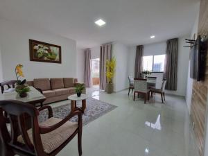 ein Wohnzimmer mit Sofa und Tisch in der Unterkunft Sobrado a 200m da Praia e Orla, 02 QTS com ar condicionado in Aracaju