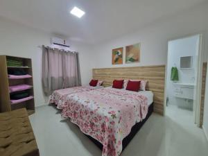 um quarto com 2 camas e almofadas vermelhas em Sobrado a 200m da Praia e Orla, 02 QTS com ar condicionado em Aracaju