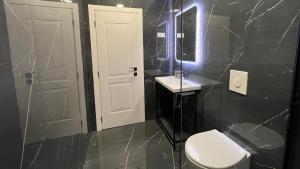 a black bathroom with a toilet and a sink at Vila 90 Boutique Hotel in Tirana