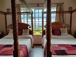2 hemelbedden in een slaapkamer met een raam bij Kisuri Resort 