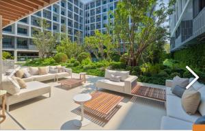 a patio with couches and tables and a building at DusitD2 Hua Hin - One bedroom with a beautiful view of the garden and pool in Hua Hin