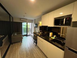 a kitchen with a counter top and a living room at DusitD2 Hua Hin - One bedroom with a beautiful view of the garden and pool in Hua Hin