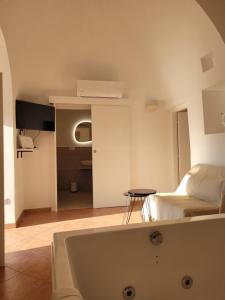 a white bath tub in a room with a bed at Trullo il Gelso in San Michele Salentino