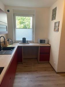 a kitchen with a counter with a microwave and a window at Großzügige Wohnung in Lüdenscheid +11 photos