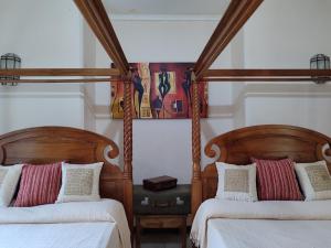 een slaapkamer met 2 bedden met houten palen bij Kisuri Resort 