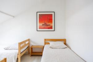 a bedroom with two beds and a picture on the wall at Le blanc droit 3éme étage droite 23A in Le Blanc-Mesnil