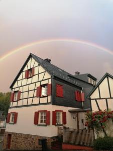 un arco iris sobre una casa con persianas rojas en Ferienwohnung CONNI, en Hellenthal