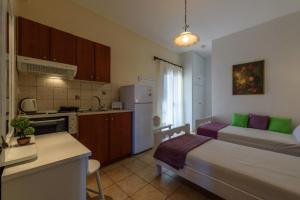 ein Schlafzimmer mit einem Bett und eine Küche mit einer Theke in der Unterkunft Angelika in Stoupa