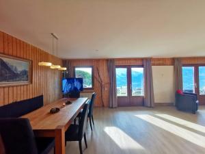 a dining room with a wooden table and chairs at Apartment with the most beautiful panorama view! - 4 Bedrooms, 2 Bathrooms, Big Corner GARDEN with WIDE VIEW on the Mountains and the Amazing Rhone Valley! in Veysonnaz