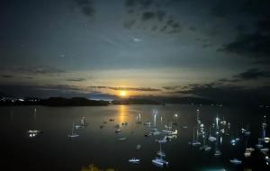 Andriana Resort & Spa في نوسي بي: إطلالة على ميناء في الليل مع قوارب في الماء