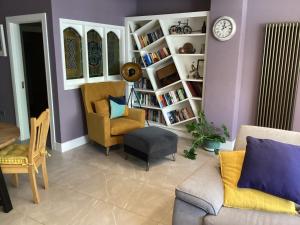 ein Wohnzimmer mit einem Sofa, Stühlen und einer Uhr in der Unterkunft Quayside luxury apt Roundstoneselfcatering in Roundstone