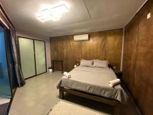 een slaapkamer met een bed en een houten muur bij Pondok Beach Shack in Tioman Island