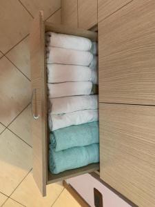 - un placard avec une pile de serviettes dans la salle de bains dans l'établissement Lungomare Apartment, à Vlorë