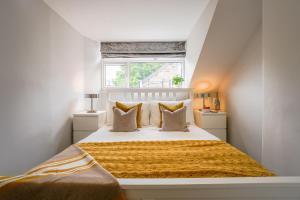 Un dormitorio con una cama con una manta amarilla. en The Bribie en Harrogate