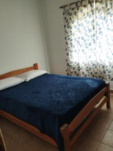 a bedroom with a bed with a blue mattress and a window at Cabañas de Ayui in Concordia