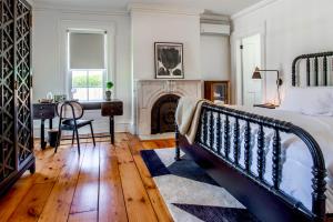 a bedroom with a bed and a desk and a fireplace at Vine & Sand--Southold NY's Newest B&B in Southold