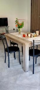 un grande tavolo in legno con sedie intorno di Vagelis Nemea apartments a Neméa