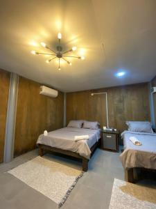 a bedroom with two beds and a ceiling fan at Pondok Beach Shack in Tioman Island
