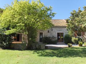 a stone house with a tree in the yard at VVF Sigean Port-la-Nouvelle Corbières in Sigean