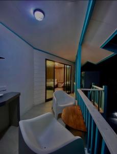 a bathroom with two chairs and a sink and a table at Pondok Beach Shack in Tioman Island