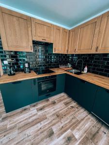 a kitchen with blue cabinets and wooden counters at Marina Olchowiec - Villa in Olchowiec
