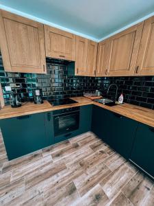 a kitchen with blue cabinets and wooden counters at Marina Olchowiec - Villa in Olchowiec +12 photos
