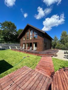 a house with a large deck in the yard at Marina Olchowiec - Villa in Olchowiec
