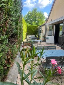 Un patio con una mesa y sillas azules. en Kyriad Epernay, en Épernay