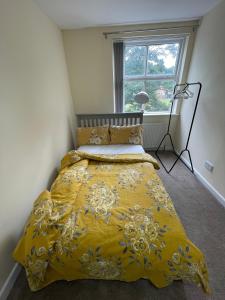 Cama amarilla en habitación con ventana en Bethel Apartments, en Leeds