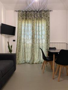 Una sala de estar con un sofá y una mesa y una ventana. en Maison Calefati, en Bari