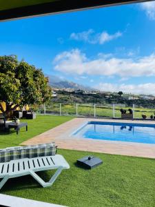 - une piscine dans une cour avec banc et pelouse dans l'établissement El Mirador de El Paso - Vistas y piscina, à El Paso