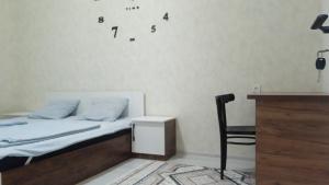 sypialnia z łóżkiem, biurkiem i krzesłem w obiekcie Begzod's house w Samarkandzie