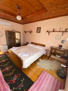um quarto com uma cama grande e um tecto de madeira em Vila Llulla em Krujë