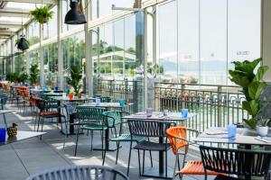 a restaurant with tables and chairs and windows at Araba Fenice Hotel in Iseo