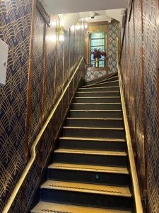eine Reihe von Treppen in einem Gebäude mit Goldgeländer in der Unterkunft The Walrus Bar and Hostel in London