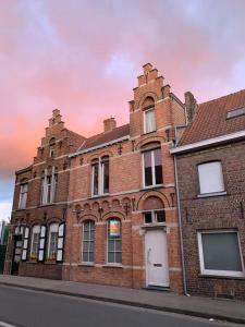 un viejo edificio de ladrillo al lado de una calle en Burgerwoning bij Brugge, en Brujas