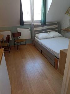ein kleines Zimmer mit einem Bett, einem Tisch und Stühlen in der Unterkunft Appartement, place Morny. in Deauville