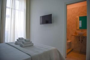 a room with a bed with towels and a television at Napoli Central Gate in Naples