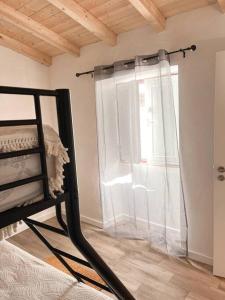 ein Schlafzimmer mit einem Bett und einem Fenster mit einem Vorhang in der Unterkunft Alqueive GUEST HOUSE in Alqueva