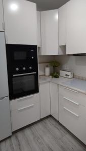 a kitchen with white cabinets and a black oven at Vivienda Villalvaro in Santander