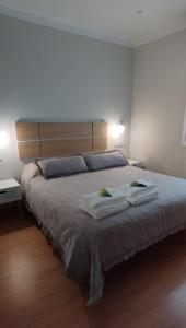 a bedroom with a large bed with two towels on it at Vivienda Villalvaro in Santander