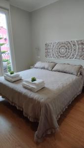 a bedroom with a large bed with towels on it at Vivienda Villalvaro in Santander