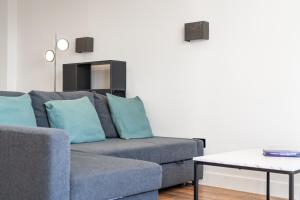 a living room with a couch and a table at 4 West London Brand New Loft in London