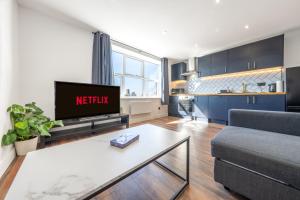 a living room with a couch and a tv at 4 West London Brand New Loft in London