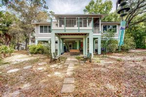 una casa con un porche con dos bancos en el patio en Suwanee House and Bungalow, en Bell