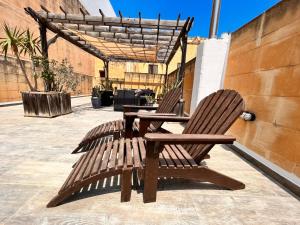 2 sillas de madera y una mesa en el patio en Carpe Diem, en Xagħra