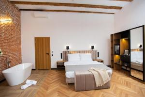 um quarto com uma cama grande e uma banheira em HOTEL TEATR em Cracóvia