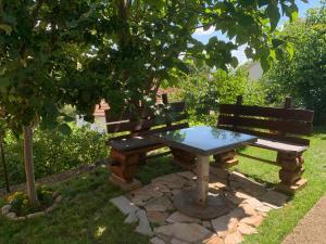 a picnic table and bench under a tree at Nature in Gacko